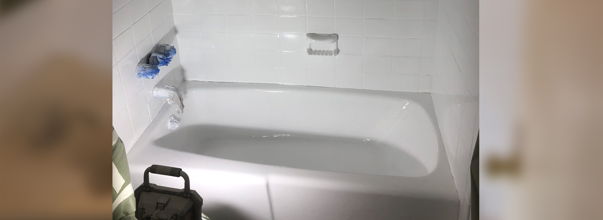 A white bathtub in a bathroom with a white tile floor.