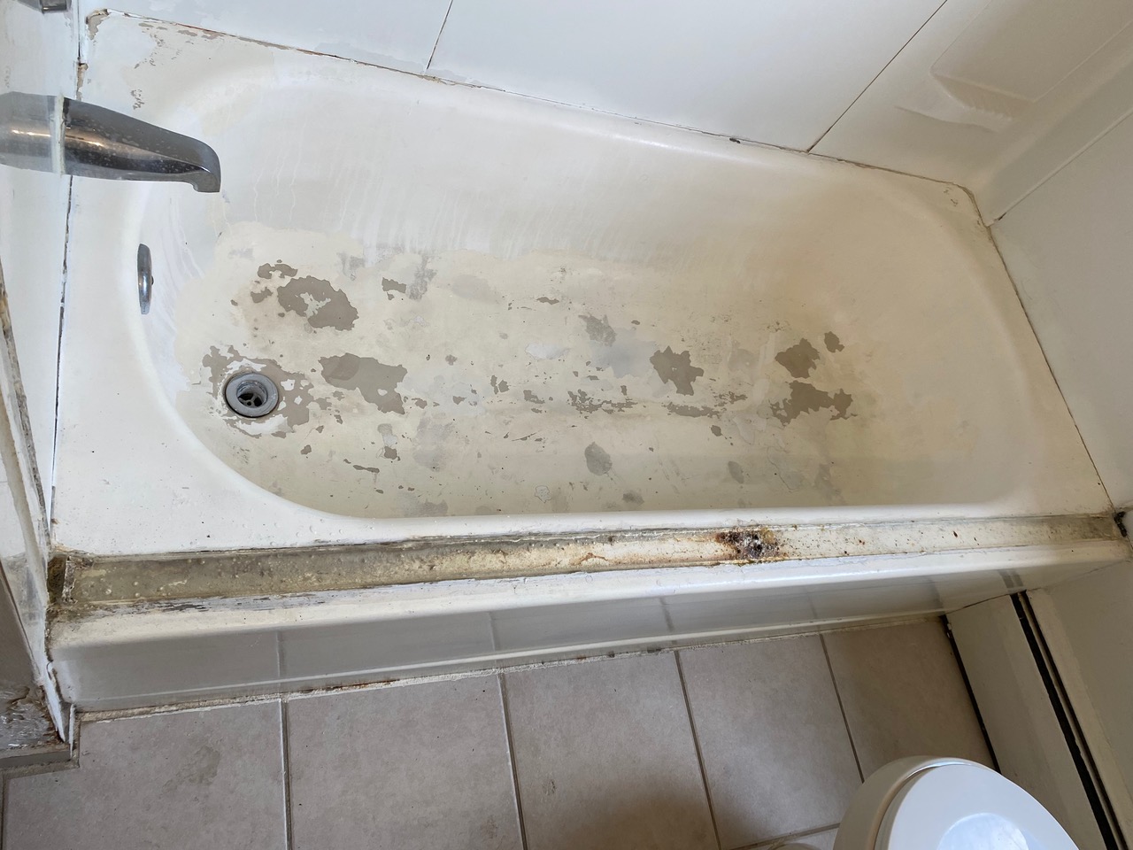 A bathroom with a bathtub and toilet in it.