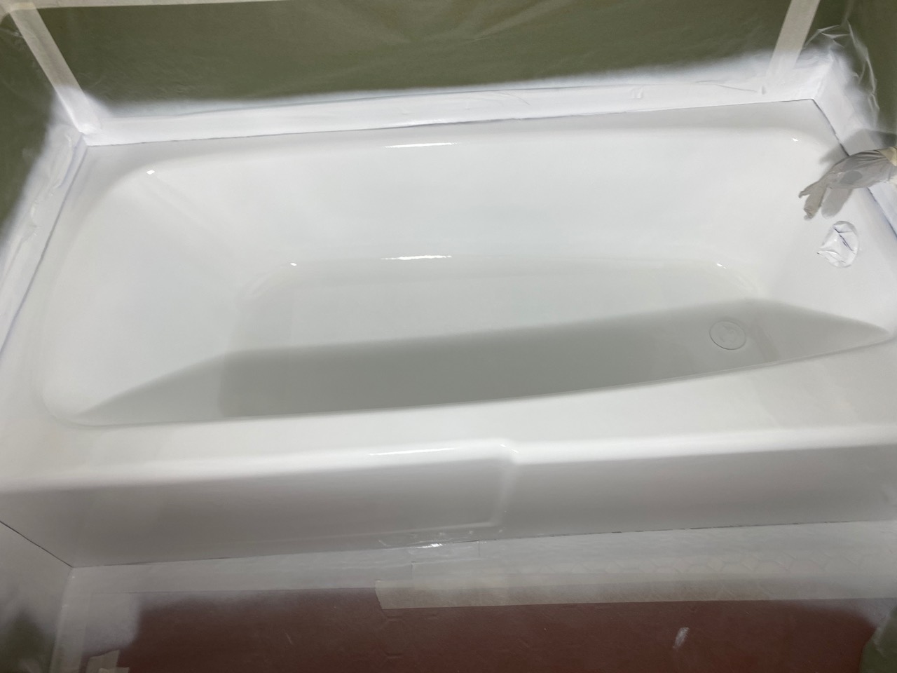 A white bathtub sitting on top of a wooden floor.