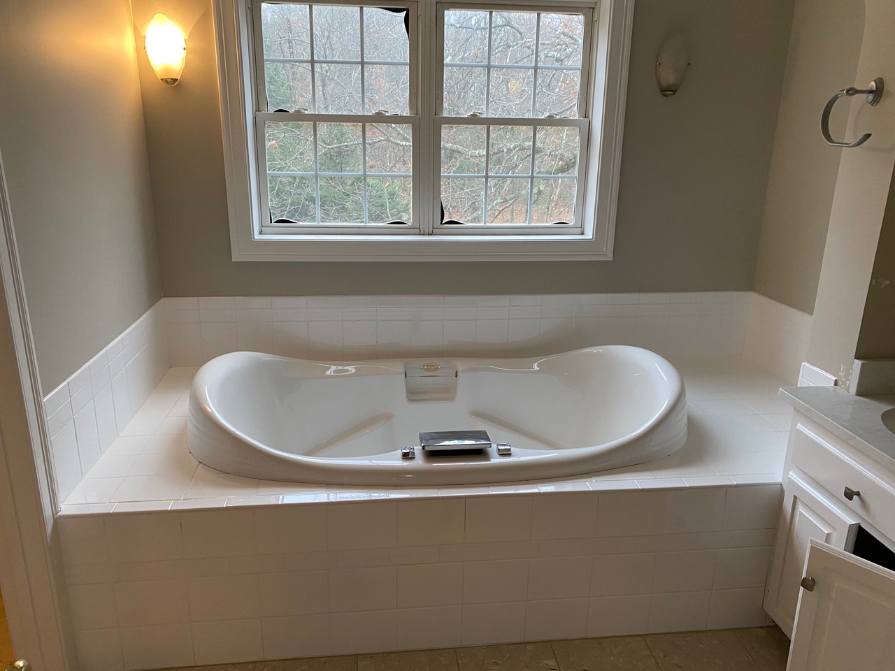 A large white tub in the middle of a bathroom.